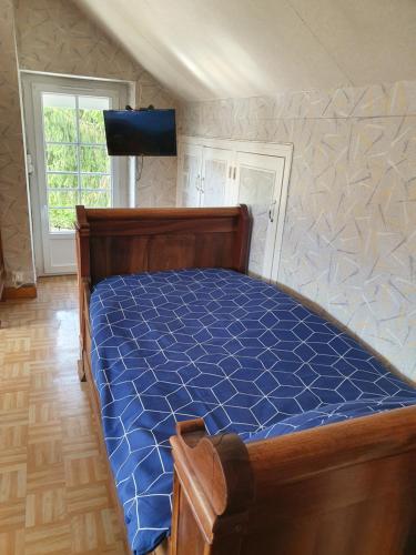 a bedroom with a bed with a blue comforter at Gîte de Montapeine in Breteau