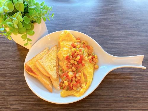 a white plate with a plate of food with a spoon at Sitio Uno Residences in Roxas City