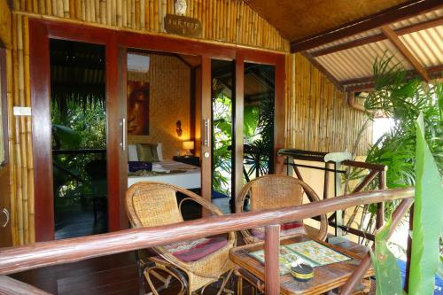 a porch with a table and chairs on it at Baan Sukreep Resort in Chaweng Noi Beach