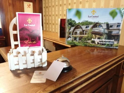 a desk with a clock and two posters on it at Hotel La Castel Iasi in Iaşi
