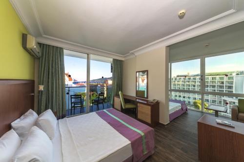 a hotel room with a bed and a balcony at Sunbay Park Hotel in Marmaris