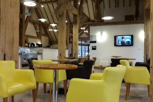 a dining room with yellow chairs and a table at Carnoustie Lodge in Wisbech