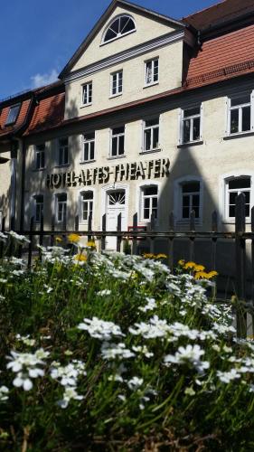 Un bâtiment avec un bouquet de fleurs devant lui dans l'établissement HOTEL ALTES THEATER Heilbronn, à Heilbronn