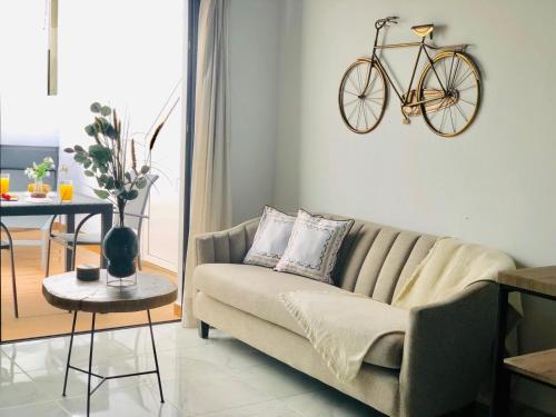 a living room with a couch and a bike on the wall at Canaryislandshost l Nazaret Suites in Nazaret