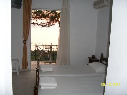 a bedroom with a bed and a window with a view at Ermones Mare in Ermones