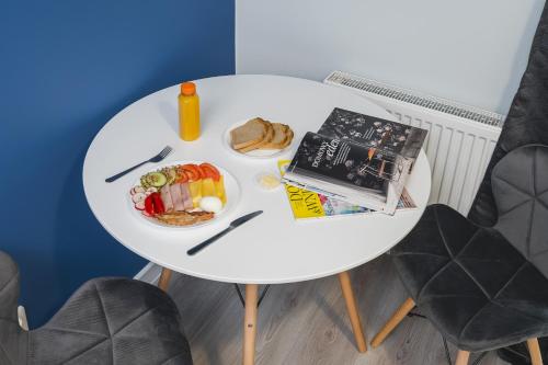a white table with a plate of food on it at K12 Apartments in Krakow