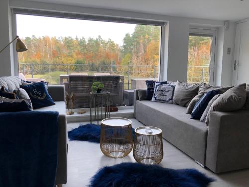 a living room with two couches and a large window at Comfort Zone Ostróda Ruś Mała in Ostróda