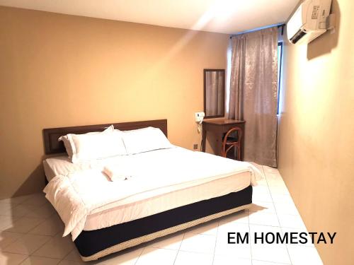a bedroom with a bed with white sheets and a window at EM HOMESTAY(Coral Bay 3Room Apartment) in Pangkor