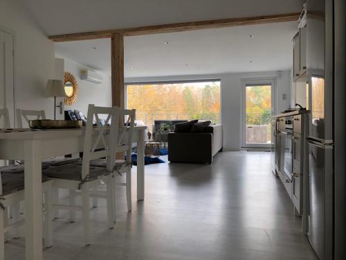 a living room with a white table and a kitchen at Comfort Zone Ostróda Ruś Mała in Ostróda