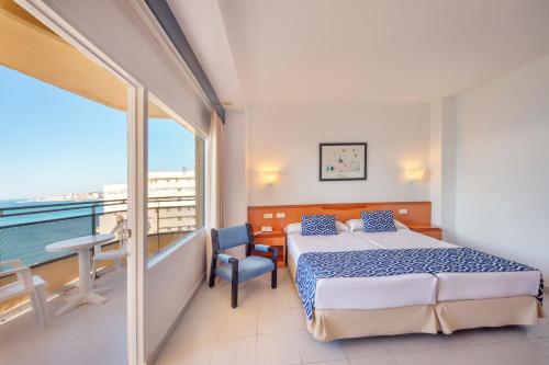 sypialnia z łóżkiem i balkonem w obiekcie Globales Gardenia w mieście Fuengirola