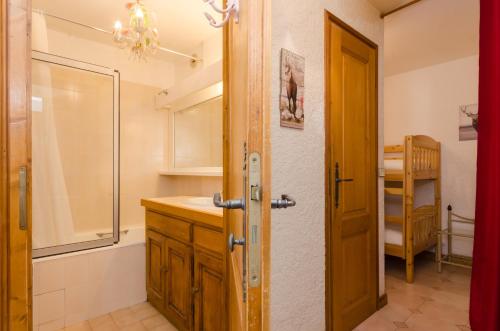 a bathroom with a sink and a shower and a door at Appartement Le Chamois in Megève