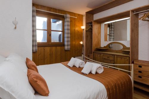 a bedroom with a large white bed with two pillows at Appartement Le Chamois in Megève