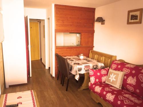 a dining room with a table and a couch at Le Rond Point des Pistes in Tignes