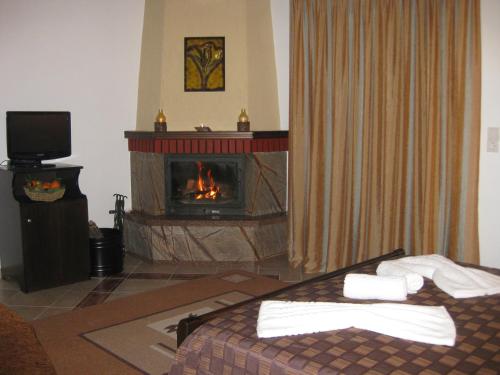 sala de estar con chimenea y cama en Guesthouse Moucha en Moúcha