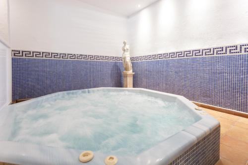 La salle de bains est pourvue d'une grande baignoire et de carrelage bleu. dans l'établissement Globales Gardenia, à Fuengirola