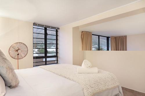 a white bedroom with a large bed and a window at G Zero 3 @ The Breakers in Hout Bay