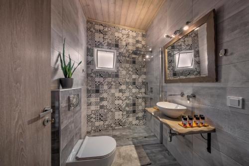 a bathroom with a toilet and a sink and a mirror at Macrame Suites in Tríkala