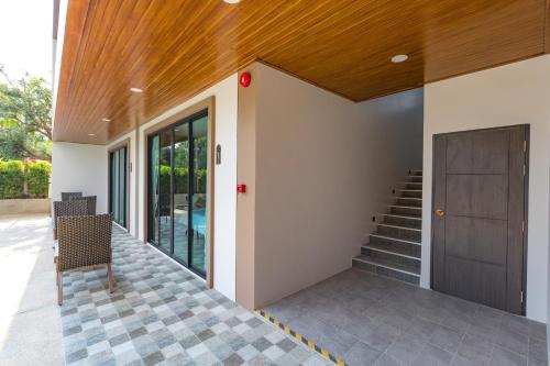 a hallway of a house with a door and stairs at The Bell Airport Phuket Hotel - SHA Extra Plus in Nai Yang Beach
