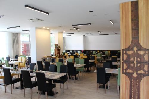 een eetkamer met tafels en stoelen bij Hotel Alpina in Kranjska Gora