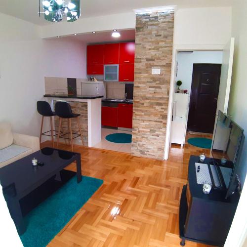 a living room and kitchen with red cabinets and a table at Agape C-52 in Trebinje
