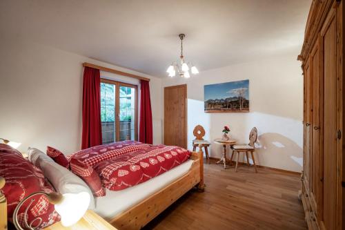 a bedroom with a bed with red pillows and a window at Grillinghof in Kirchberg in Tirol