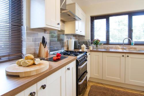 una cucina con armadi bianchi e piano cottura di No4 Low House Cottages a Coniston