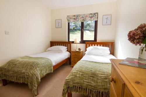 una camera con due letti e una finestra di No4 Low House Cottages a Coniston