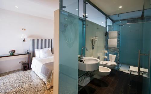 a bathroom with a bed and a sink and a mirror at Ca' Nigra Lagoon Resort Adults Only in Venice