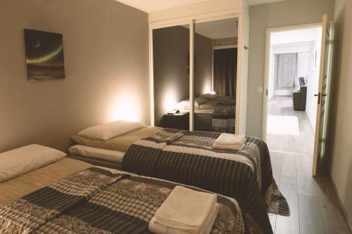 1 dormitorio con 2 camas y espejo en Apartment Rovakatu 27 B 10 en Rovaniemi