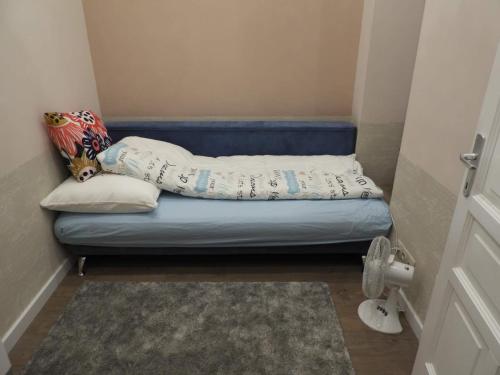 a small room with a blue bed with pillows on it at Gizella apartman in Budapest