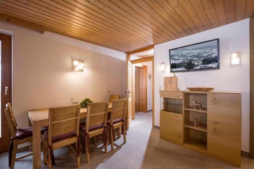 a dining room with a table and a tv on a wall at Grillinghof in Kirchberg in Tirol