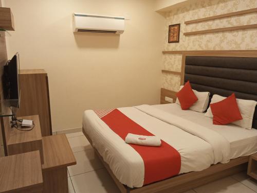 een slaapkamer met een bed en een televisie. bij Hotel rr palace in Ahmedabad