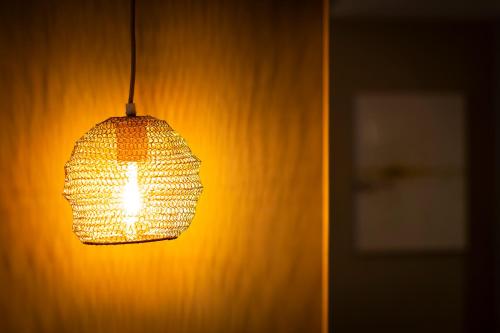a lamp hanging from a wall in a room at Aparthotel 37 Lodge Courbevoie Paris La Défense in Courbevoie