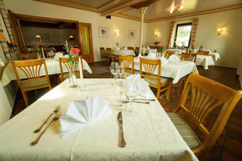 a dining room with tables and chairs with white tablecloths at Gasthaus zum Rössel Lichtenau in Scherzheim