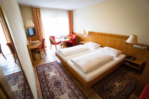 um quarto de hotel com uma cama e uma mesa em Gasthaus zum Rössel Lichtenau em Scherzheim