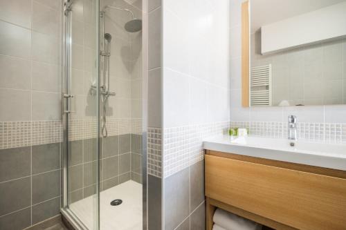 een badkamer met een douche en een wastafel bij Logis Hôtel Restaurant Le Coq Hardi in Pouilly-sur-Loire