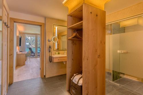 y baño con ducha, lavabo y espejo. en haldensee - Naturerlebnis und Wellnesshotel en Nesselwängle