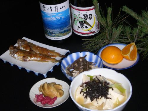 a table topped with plates of food and drinks at Tamonkan in Tsuruoka