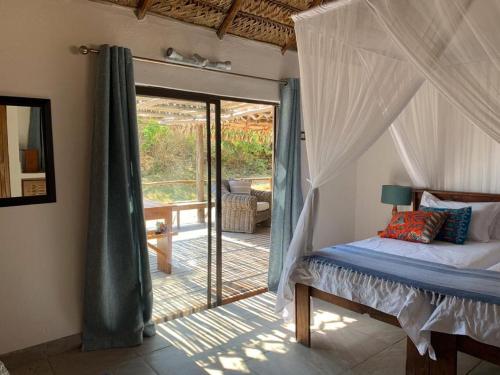 a bedroom with a bed and a door to a patio at Sava Dunes in Miramar