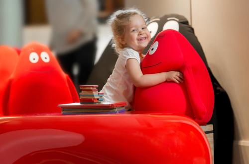 a little girl sitting in a red car seat at Sydney Central Hotel managed by The Ascott Limited in Sydney