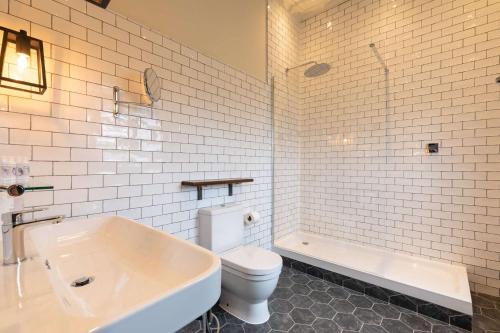 a bathroom with a toilet and a tub and a sink at The Park Hotel in Teddington