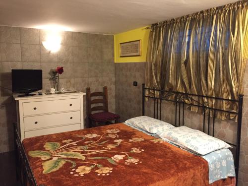 una camera con letto, cassettiera e televisore di Il Giardino della Foglia a Bari Palese