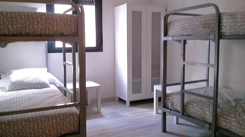 a bedroom with a bunk bed and two bunk beds at Albergue Muralla Leonesa in León