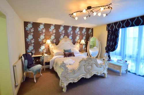 a hotel room with a bed, chair, and nightstand at Angmering Manor Hotel in Angmering