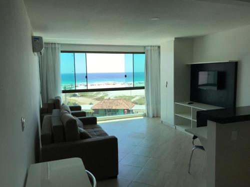 a living room with a couch and a view of the ocean at Sophia II Residence Inn in Arraial do Cabo