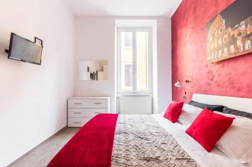 una camera da letto bianca e rossa con una parete con accento rosso di Riari 59 Rome - Trastevere a Roma