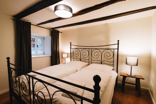 1 dormitorio con 1 cama grande con marco negro en Holiday House BURGBLICK1 with terrace - VOSPROPERTIES en Monschau