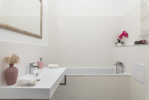 布達佩斯的住宿－Milano Design Apartment City Center，白色的浴室设有白色浴缸和水槽。