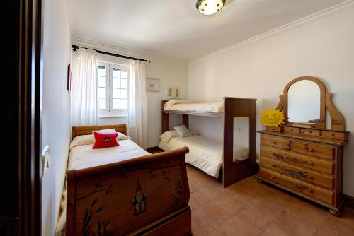a bedroom with two bunk beds and a dresser and a mirror at FINCA EL PIRUETANO in Toledo