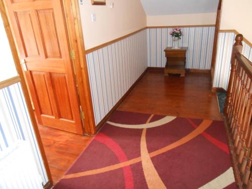 a hallway with a door and a rug on the floor at Birchdale House B&B in Rathdrum